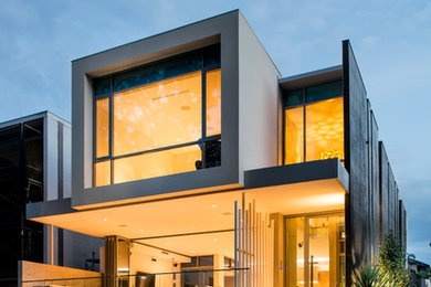Photo of a small contemporary three-storey concrete yellow exterior in Perth.