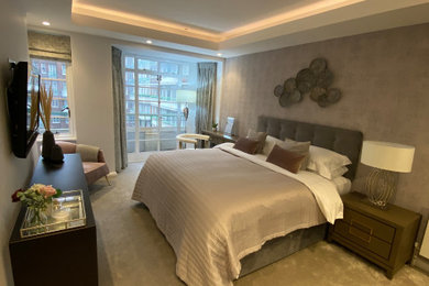 Bedroom - mid-sized modern master carpeted, beige floor, tray ceiling and wallpaper bedroom idea in London with gray walls