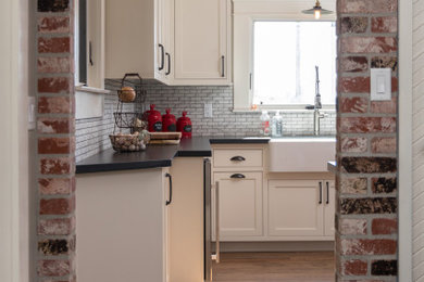 Mid-sized cottage u-shaped dark wood floor and brown floor enclosed kitchen photo in Other with a farmhouse sink, shaker cabinets, white cabinets, quartz countertops, multicolored backsplash, porcelain backsplash, stainless steel appliances and gray countertops