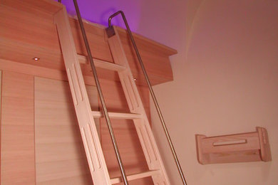 Imagen de escalera recta contemporánea pequeña con escalones de madera y barandilla de metal