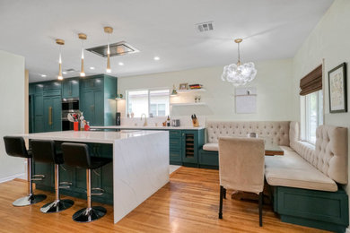 Kitchen photo in Los Angeles with a drop-in sink, shaker cabinets, green cabinets, quartzite countertops, white backsplash, stainless steel appliances, an island and white countertops