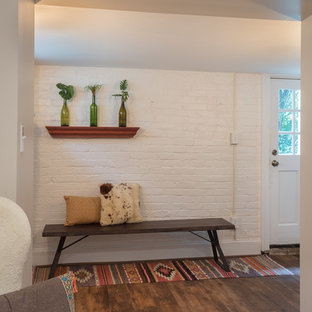 Idées déco pour une petite porte d'entrée éclectique avec un mur blanc, un sol en vinyl, une porte simple, une porte blanche et un sol marron.
