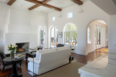 Living room - mediterranean medium tone wood floor and brown floor living room idea in San Diego with white walls and a standard fireplace