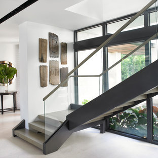 Modelo de escalera en L, costera, sin contrahuella, con escalones de hormigón y barandilla de vidrio