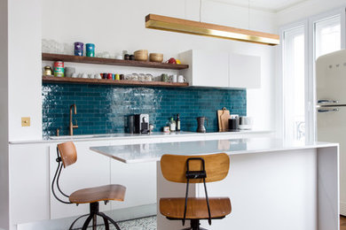 Réalisation d'une cuisine ouverte parallèle et haussmannienne design de taille moyenne avec plan de travail en marbre, une crédence bleue, une crédence en céramique, carreaux de ciment au sol, îlot, un plan de travail blanc, un placard à porte plane, des portes de placard blanches, un électroménager blanc et un sol multicolore.