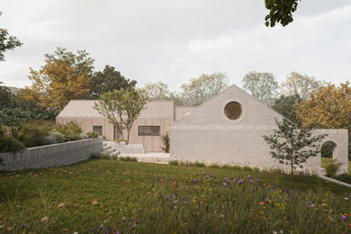 Photo of a medium sized scandinavian side formal full sun garden for summer in Oxfordshire with a flowerbed and natural stone paving.