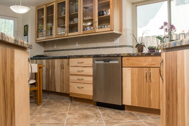 Inspiration for a mid-sized rustic u-shaped ceramic tile eat-in kitchen remodel in San Diego with a drop-in sink, glass-front cabinets, light wood cabinets, granite countertops, beige backsplash, subway tile backsplash, stainless steel appliances and no island