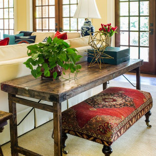 Großes, Offenes Mediterranes Wohnzimmer mit gelber Wandfarbe, dunklem Holzboden, Kamin, Kaminsims aus Beton und Wand-TV in Atlanta