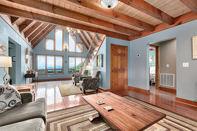 Example of a minimalist open concept dark wood floor living room design in Other with blue walls, a standard fireplace, a wood fireplace surround and a tv stand