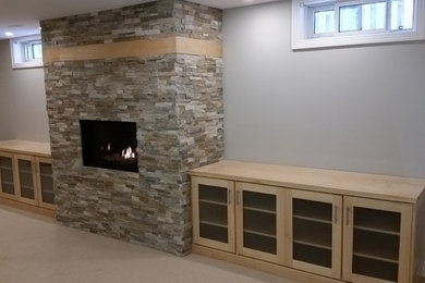 Example of a small trendy carpeted and gray floor basement design in Other with gray walls, a standard fireplace and a stone fireplace