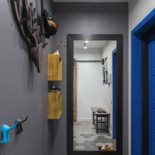 Пример оригинального дизайна интерьера: маленькая входная дверь в скандинавском стиле с серыми стенами, полом из керамогранита, одностворчатой входной дверью, синей входной дверью и серым полом