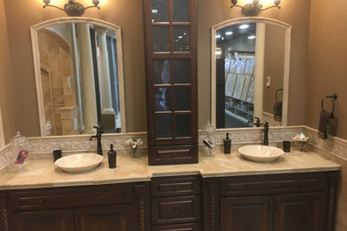Large tuscan master beige tile and travertine tile travertine floor and beige floor bathroom photo in New York with raised-panel cabinets, dark wood cabinets, beige walls, a vessel sink and tile countertops