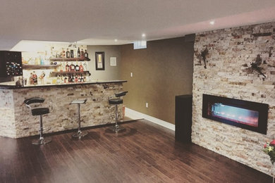 Photo of a large contemporary galley seated home bar in Other with dark hardwood floors, brown floor, no sink, open cabinets, dark wood cabinets, soapstone benchtops and black benchtop.