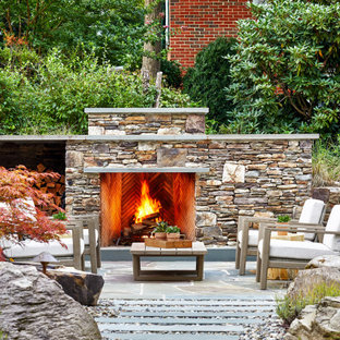 ワシントンD.C.の大きいトランジショナルスタイルのおしゃれな裏庭のテラス (屋外暖炉、天然石敷き、日よけなし) の写真