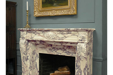 Inspiration for a medium tone wood floor living room remodel in New York with blue walls, a standard fireplace and a stone fireplace
