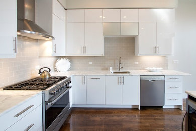 Inspiration for a mid-sized contemporary l-shaped dark wood floor and brown floor open concept kitchen remodel in New York with an undermount sink, flat-panel cabinets, white cabinets, quartz countertops, white backsplash, glass tile backsplash, stainless steel appliances and an island