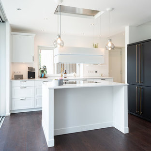 Удачное сочетание для дизайна помещения: маленькая кухня в стиле кантри с белыми фасадами, фартуком с окном, черной техникой, темным паркетным полом, островом, коричневым полом и белой столешницей - самое интересное для вас