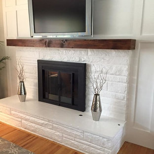 Inspiration för ett mellanstort funkis separat vardagsrum, med vita väggar, ljust trägolv, en standard öppen spis, en spiselkrans i tegelsten och en väggmonterad TV