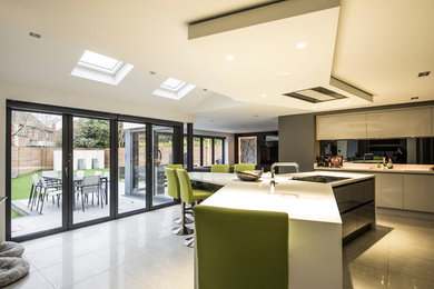 This is an example of a large contemporary l-shaped open plan kitchen in Manchester with flat-panel cabinets and a peninsula.