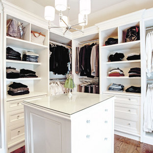 Aménagement d'un dressing classique de taille moyenne et neutre avec un placard avec porte à panneau encastré, des portes de placard blanches, un sol en bois brun, un sol marron et un plafond à caissons.