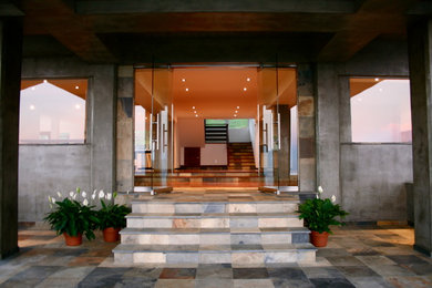 Entryway - large contemporary slate floor entryway idea in Hawaii with beige walls and a glass front door
