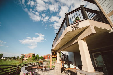 Example of a mid-sized trendy backyard deck design in Denver with no cover