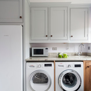 ウィルトシャーの小さいトラディショナルスタイルのおしゃれなランドリールーム (インセット扉のキャビネット、御影石カウンター、アンダーカウンターシンク、グレーのキャビネット、紫の壁、左右配置の洗濯機・乾燥機) の写真