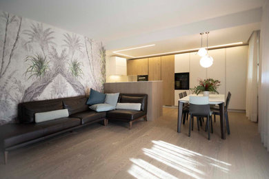 Ispirazione per una sala da pranzo aperta verso il soggiorno minimalista di medie dimensioni con pareti bianche, pavimento in legno massello medio, nessun camino e pavimento marrone
