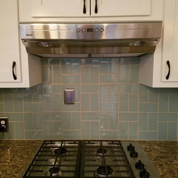 Kitchen Cabinets, blue tile, stainless stove & hood, granite countertop