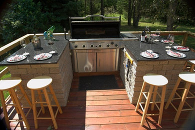 Example of a mid-sized transitional backyard outdoor kitchen deck design in Toronto with no cover