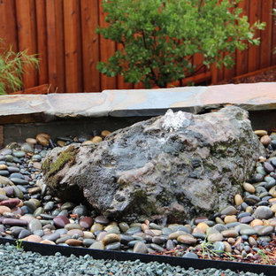 Réalisation d'un jardin à la française arrière méditerranéen de taille moyenne avec un point d'eau, une exposition partiellement ombragée et du gravier.