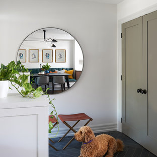 Exemple d'une porte d'entrée éclectique de taille moyenne avec un mur blanc, un sol en ardoise, une porte simple, une porte rouge et un sol noir.