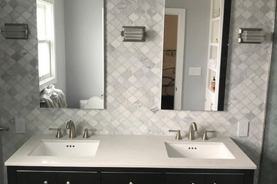 Example of a mid-sized transitional master bathroom design in San Francisco with flat-panel cabinets, black cabinets, gray walls, an undermount sink, solid surface countertops and white countertops