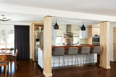 Inspiration for a mid-century modern dark wood floor eat-in kitchen remodel in Minneapolis with a single-bowl sink, flat-panel cabinets, light wood cabinets, quartz countertops, white backsplash, stainless steel appliances and an island