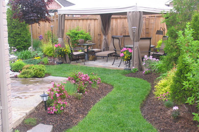 Patio - traditional backyard stone patio idea in Toronto with a gazebo