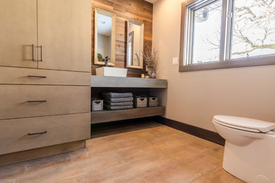 Inspiration for a mid-sized industrial master bathroom remodel in Other with a vessel sink and concrete countertops