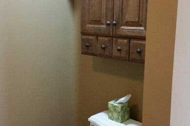 Powder room - mid-sized eclectic vinyl floor powder room idea in Other with raised-panel cabinets, dark wood cabinets, a two-piece toilet, brown walls and an integrated sink