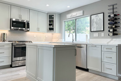 Inspiration for a transitional u-shaped porcelain tile and gray floor kitchen remodel in Orange County with a single-bowl sink, shaker cabinets, gray cabinets, quartz countertops, gray backsplash, ceramic backsplash, stainless steel appliances and white countertops