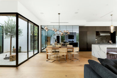 Esempio di una sala da pranzo aperta verso la cucina contemporanea di medie dimensioni con parquet chiaro e pavimento beige