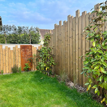 Aménagement du jardin avec des palissades en bois et des arbres palissés.