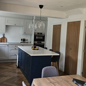 Open-Plan Kitchen and Dining Area with Navy Island and Pendant Lighting