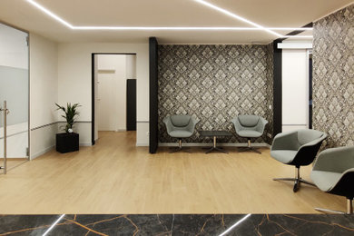 Immagine di un grande ufficio design con pareti bianche, parquet chiaro e carta da parati