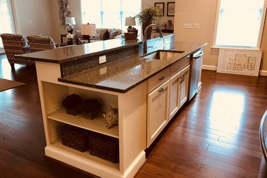 Mid-sized elegant single-wall light wood floor and beige floor open concept kitchen photo in Richmond with an undermount sink, recessed-panel cabinets, white cabinets, granite countertops, multicolored backsplash, stone slab backsplash, stainless steel appliances, an island and multicolored countertops
