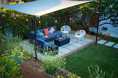 This is an example of a small drought-tolerant backyard concrete paver landscaping in Los Angeles with a fire pit.