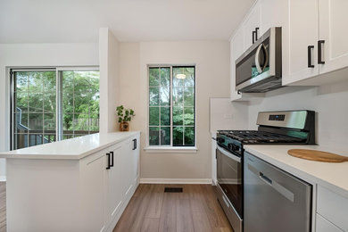 Mid-sized trendy light wood floor and beige floor eat-in kitchen photo in Chicago with an undermount sink, shaker cabinets, white cabinets, quartzite countertops, white backsplash, ceramic backsplash, stainless steel appliances, an island and white countertops