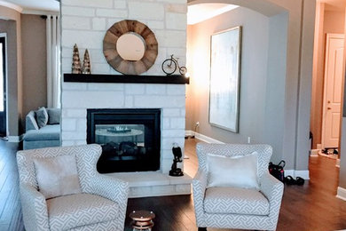 Large minimalist open concept and formal medium tone wood floor living room photo in Austin with beige walls, a two-sided fireplace, a stone fireplace and a wall-mounted tv