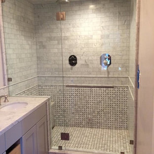 Cette image montre une petite salle de bain traditionnelle avec un carrelage noir, un carrelage noir et blanc, un carrelage blanc, des carreaux en allumettes, un mur blanc, un placard avec porte à panneau encastré, des portes de placard grises, un lavabo encastré, un plan de toilette en marbre et une cabine de douche à porte battante.