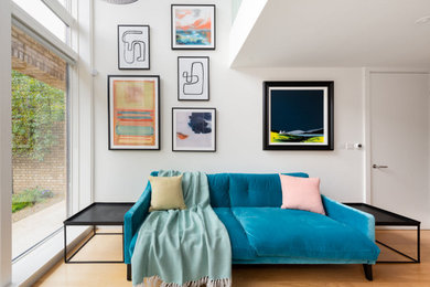 Design ideas for a medium sized modern open plan living room in Cambridgeshire with white walls, medium hardwood flooring and feature lighting.