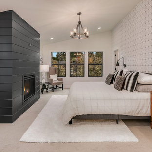 Inspiration for a large country master bedroom in Seattle with white walls, carpet, a standard fireplace, a wood fireplace surround and grey floor.