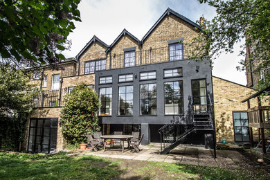 Inspiration for a large and black classic brick detached house with three floors, a pitched roof, a shingle roof and a black roof.